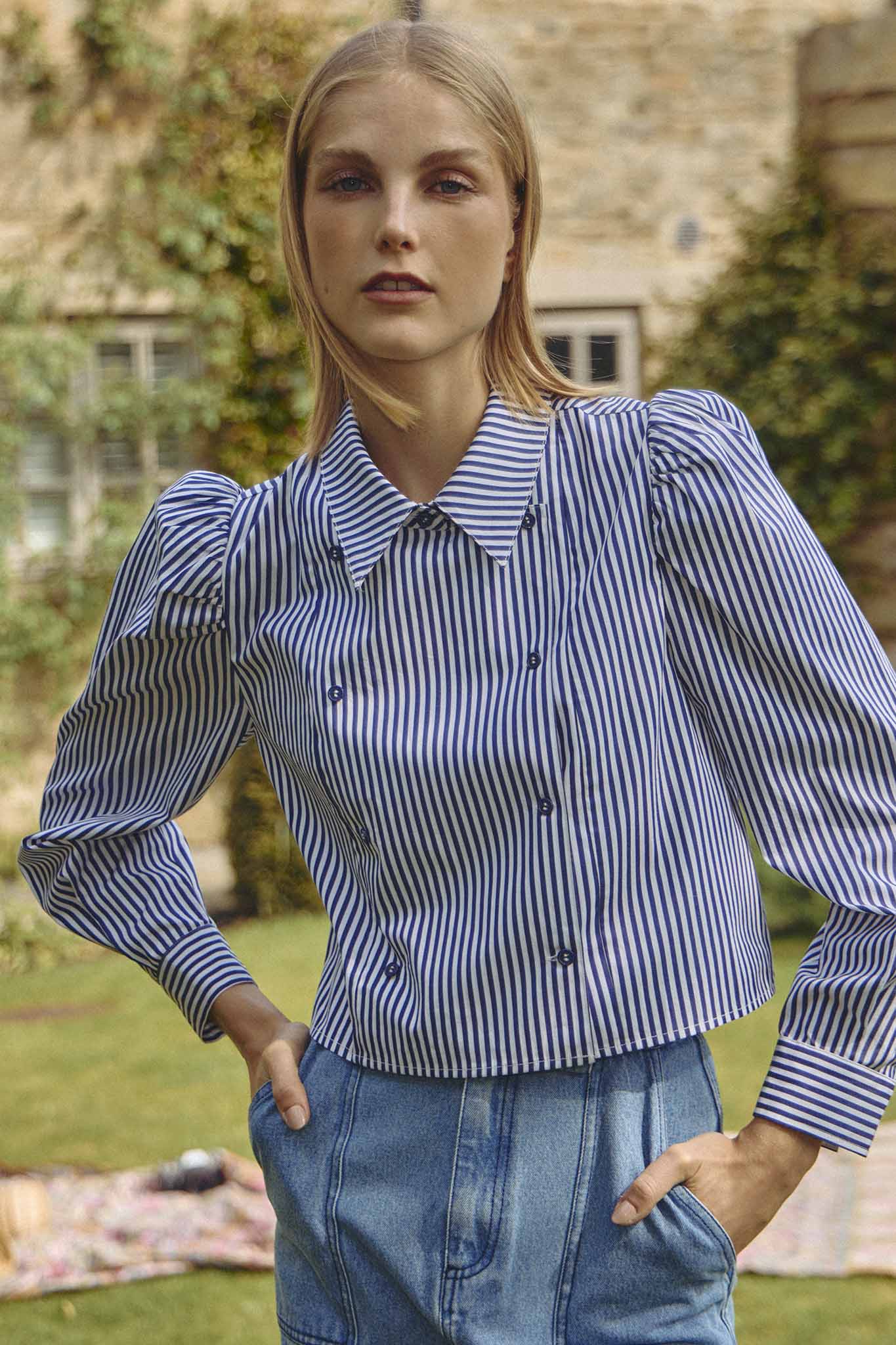 The cropped Annette Shirt is a striped long-sleeve with a double-breasted button placket.