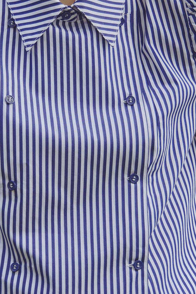 The cropped Annette Shirt is a striped long-sleeve with a double-breasted button placket.