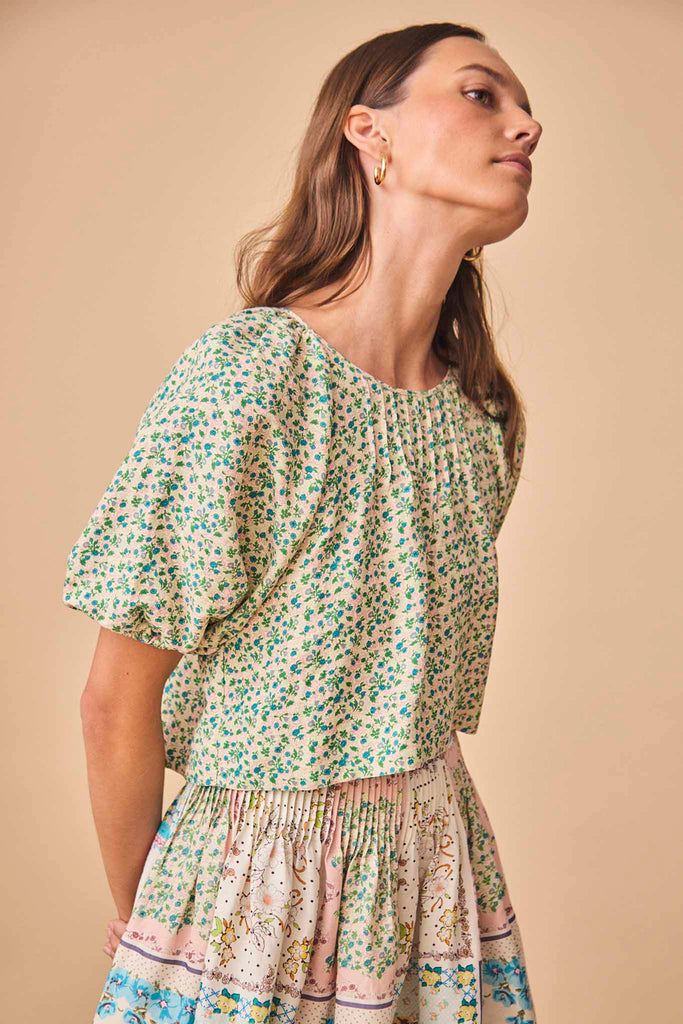 The Claudia top is designed with a relaxed profile, a round neckline and a tie back closure.