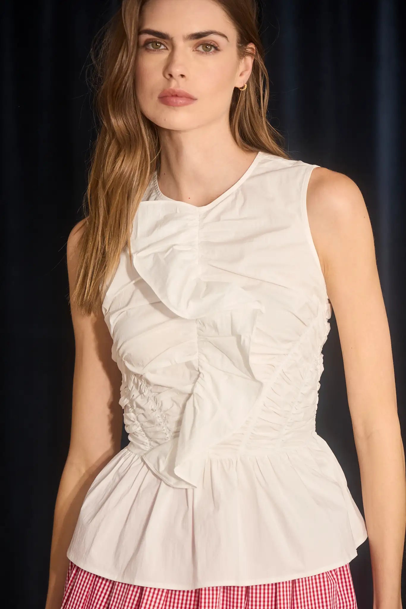 The Doering Top is a fitted V-neck silhouette with ruffles, shirring, and a peplum waist.