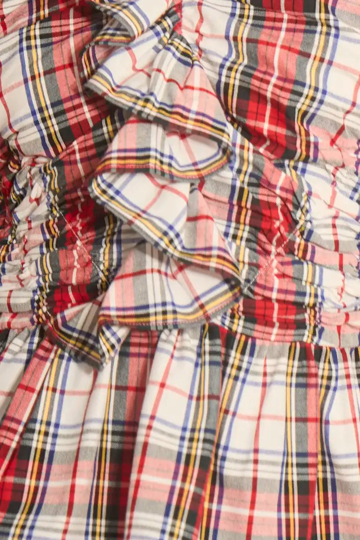 The Doering Top is a fitted V-neck silhouette with ruffles, shirring, and a peplum waist.