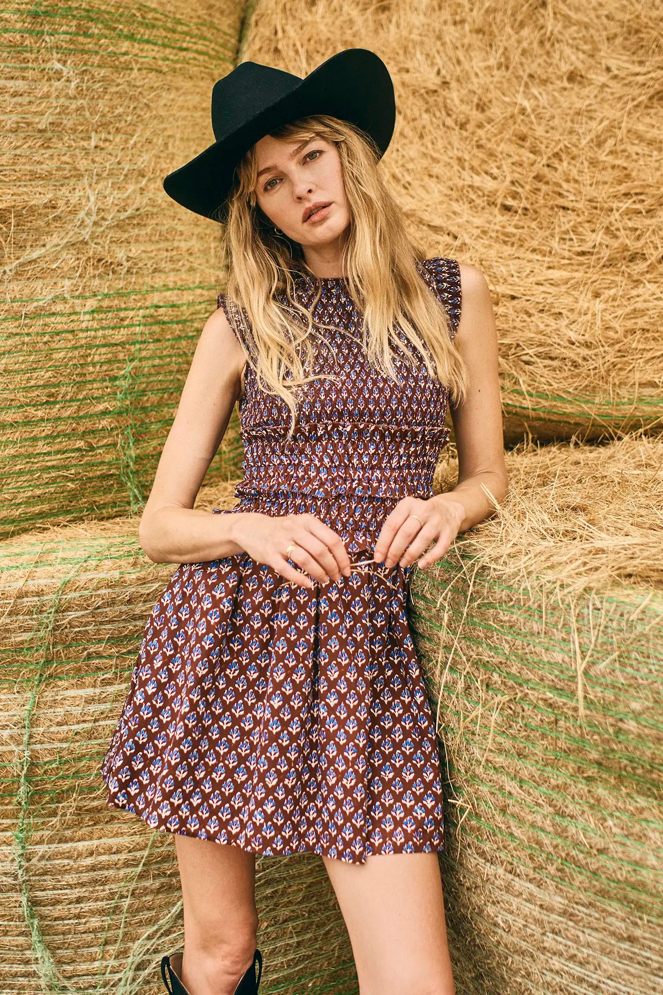 The Gweneth Dress is a sleeveless mini with a round neckline, long smocked bodice and a drop waist.