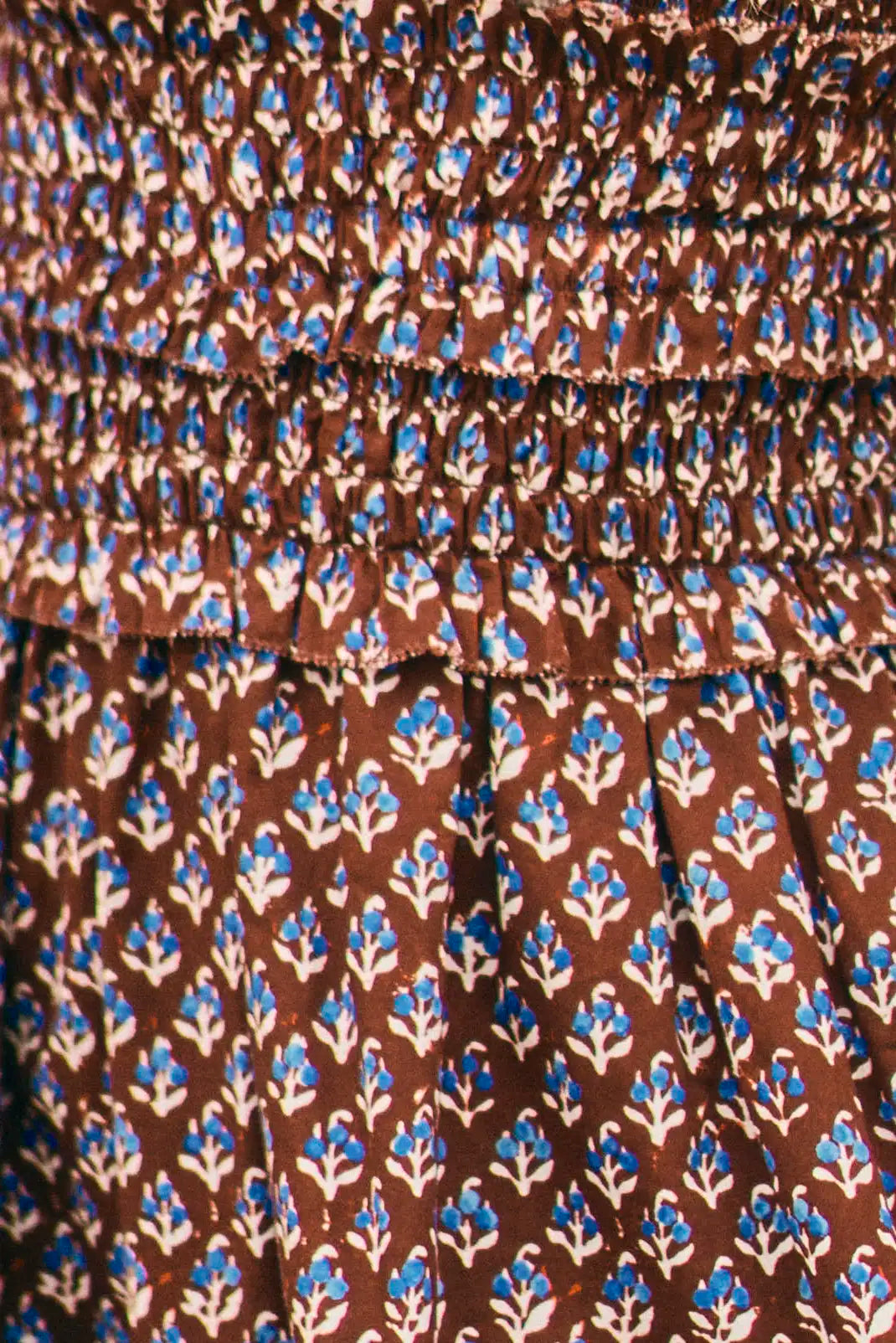 The Gweneth Dress is a sleeveless mini with a round neckline, long smocked bodice and a drop waist.