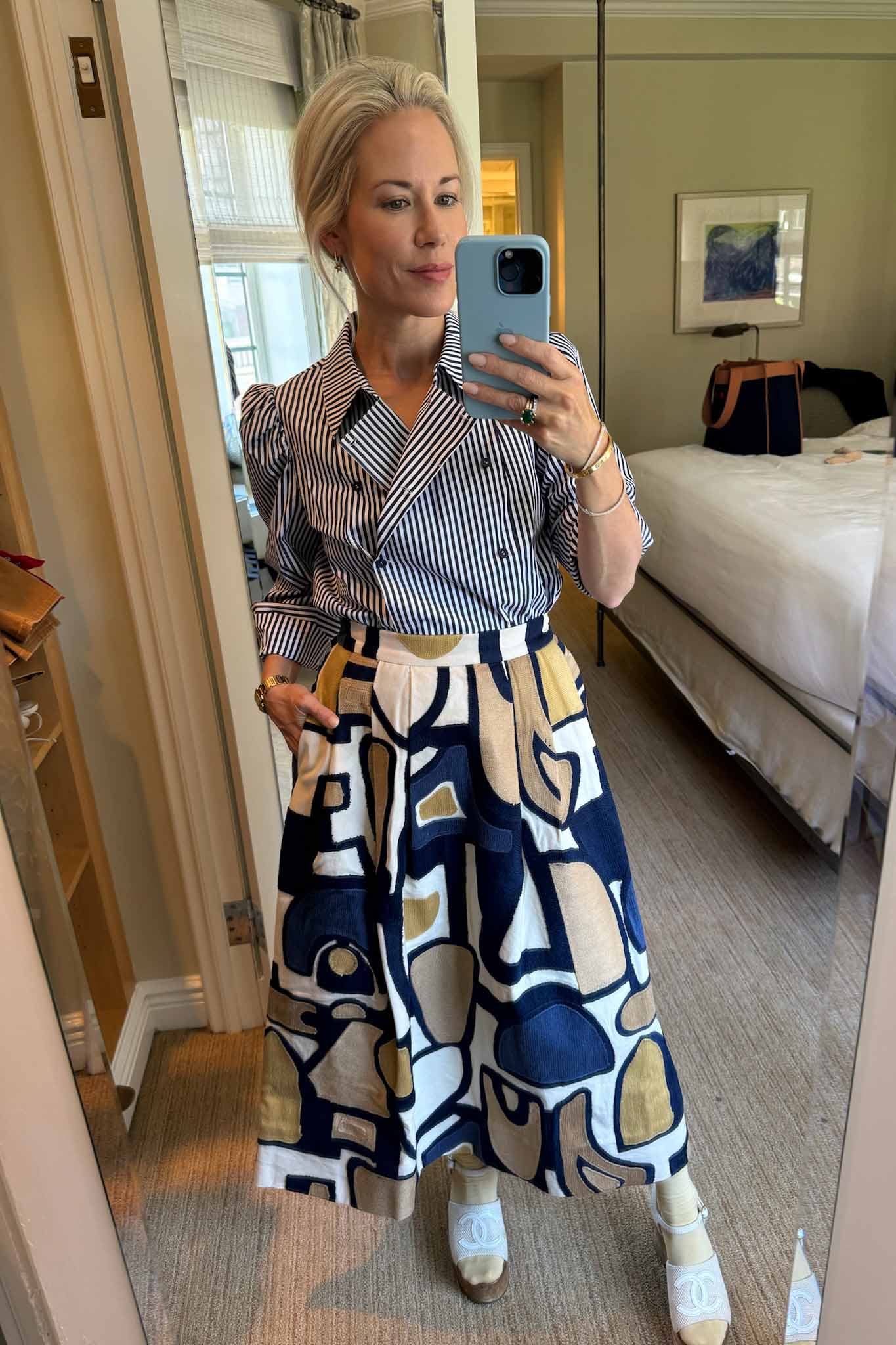 The cropped Annette Shirt is a striped long-sleeve with a double-breasted button placket.