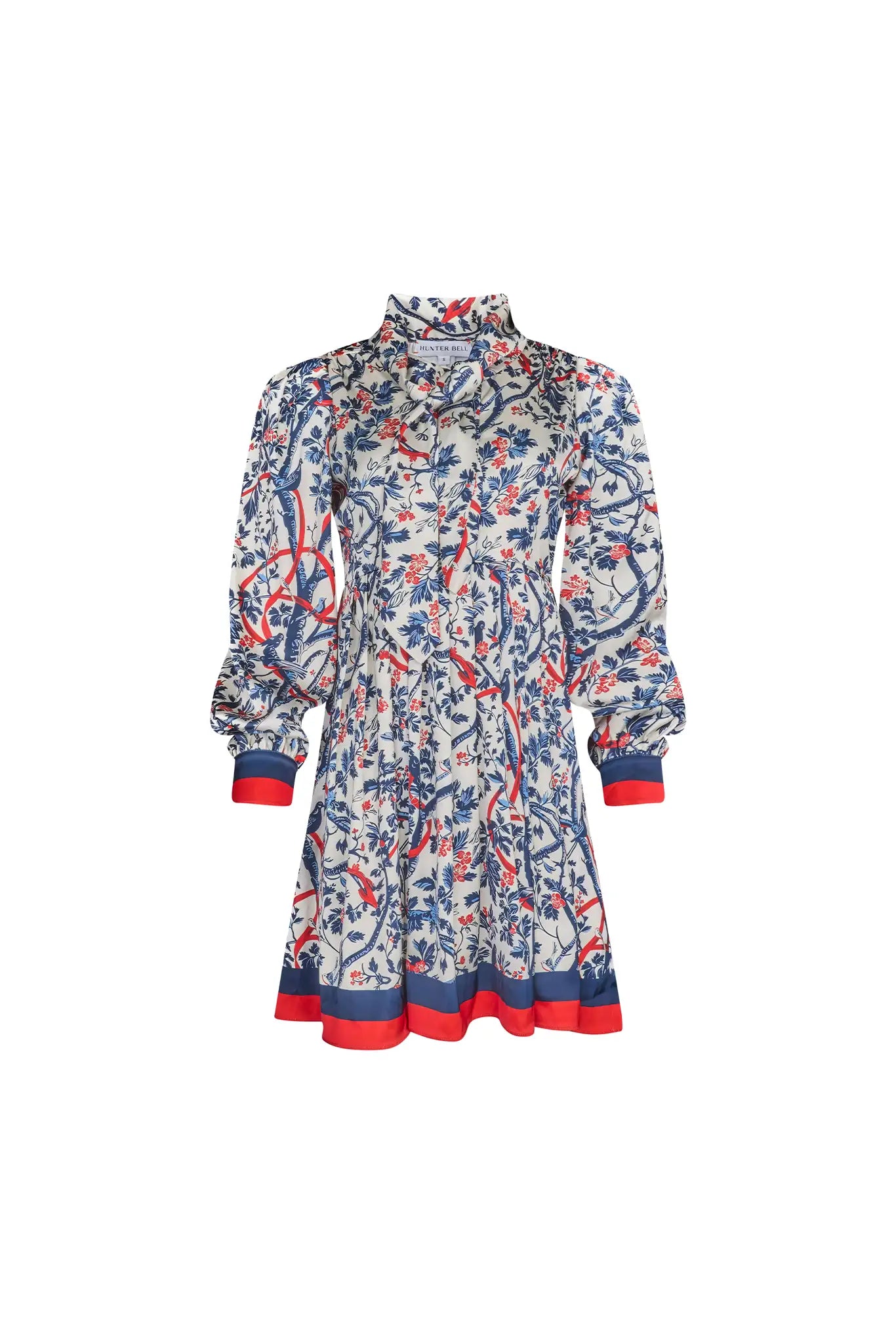 The Lila Dress is a mini with a tie neckline, long sleeves with button cuffs and a color block hem.