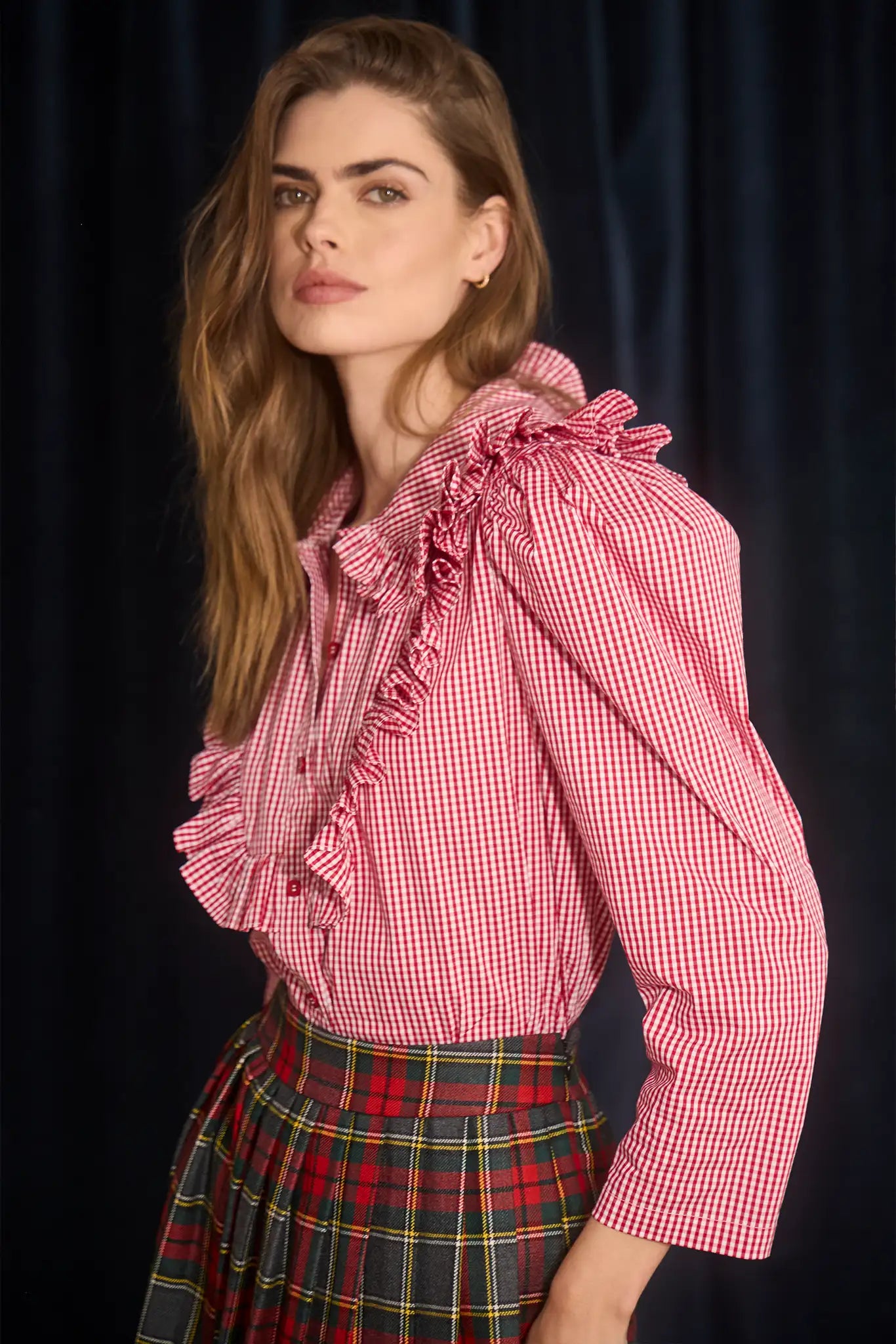 The Mae Top has a collared button front shape, ruffled yokes, and long sleeves with button cuffs.