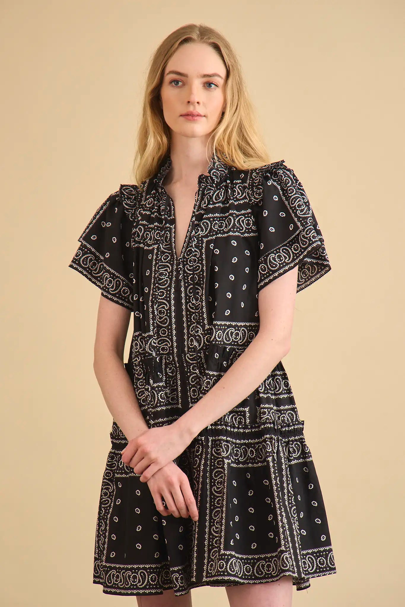 The Merritt Dress has a swing silhouette, ruffle detailing along the V-neck, and a tiered bodice.