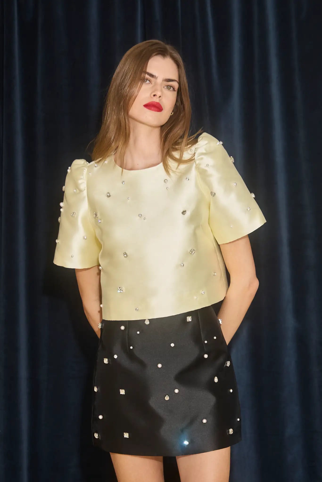 The Britt Skirt is a duchess satin black mini, hand embroidered with pearl and rhinestone detailing.