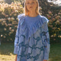 Blue cut-out embroidered linen, crew neckline, softly ruffled yoke, long sleeves with button cuffs