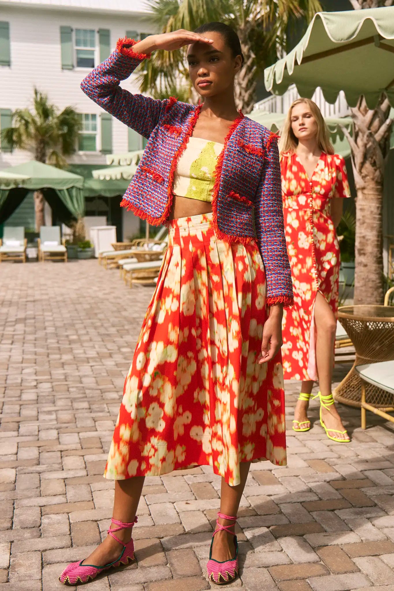 A full-length pleated orange and yellow printed skirt with a fixed waistband and functional pockets.