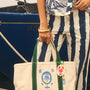 The medium canvas tote bag with green handles and fish motifs.