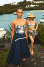 The Allegra Skirt in Navy paired with Nevis One Piece in Bermuda Toile in front of ocean. 