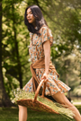 The Addison Dress, Made with Liberty Fabric floral dress, carrying a basket of florals.