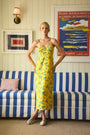 The Amal Dress in Middleton Meadow on model in front of red backdrop.