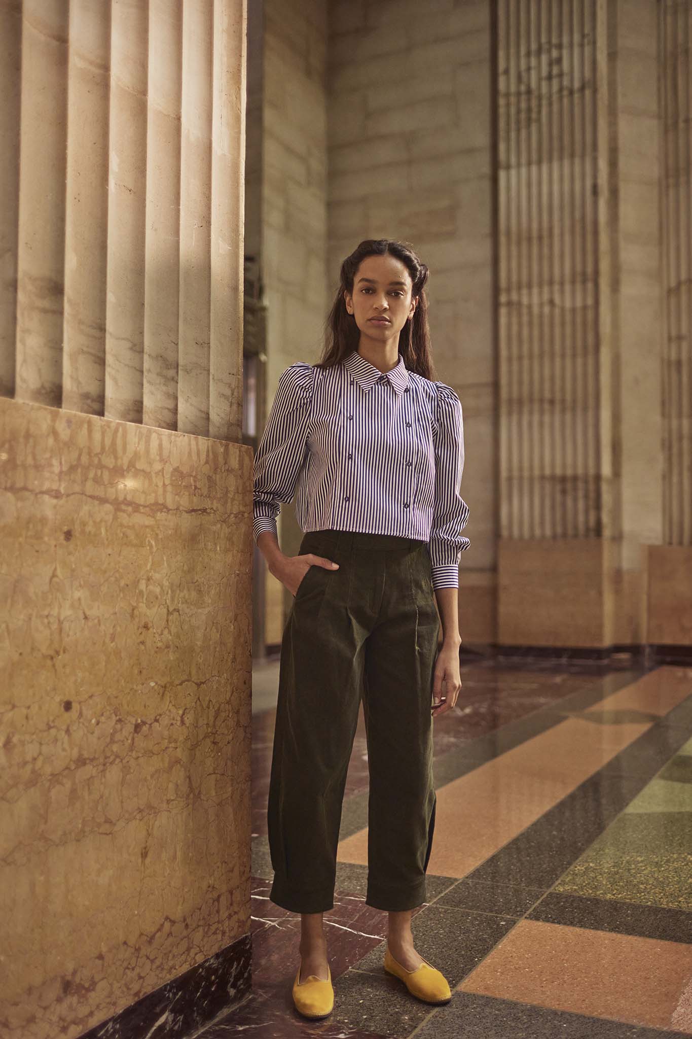 The cropped Annette Shirt is a striped long-sleeve with a double-breasted button placket.