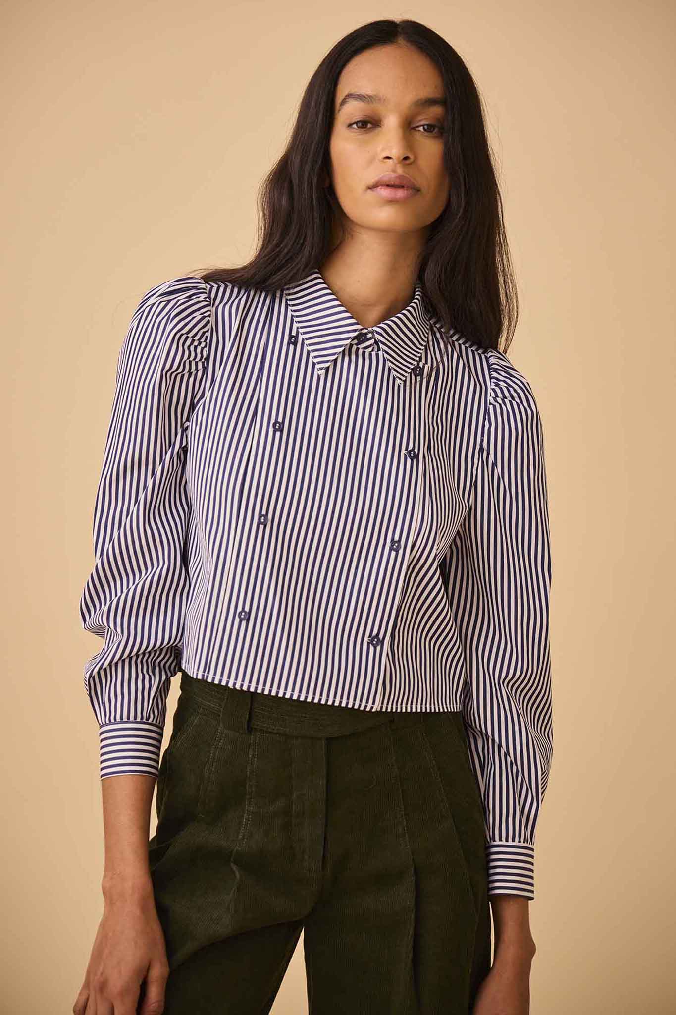 The cropped Annette Shirt is a striped long-sleeve with a double-breasted button placket.