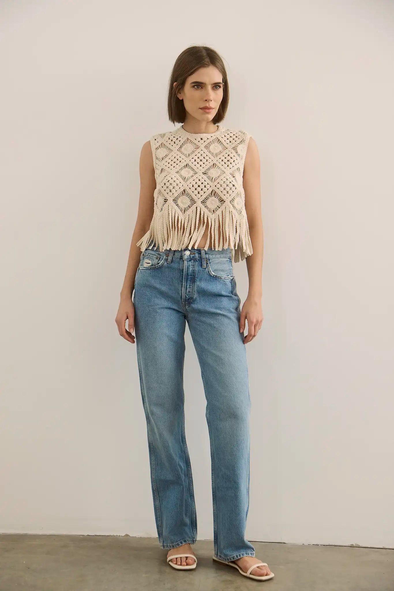 The Astor Top in cream paired with denim jeans.