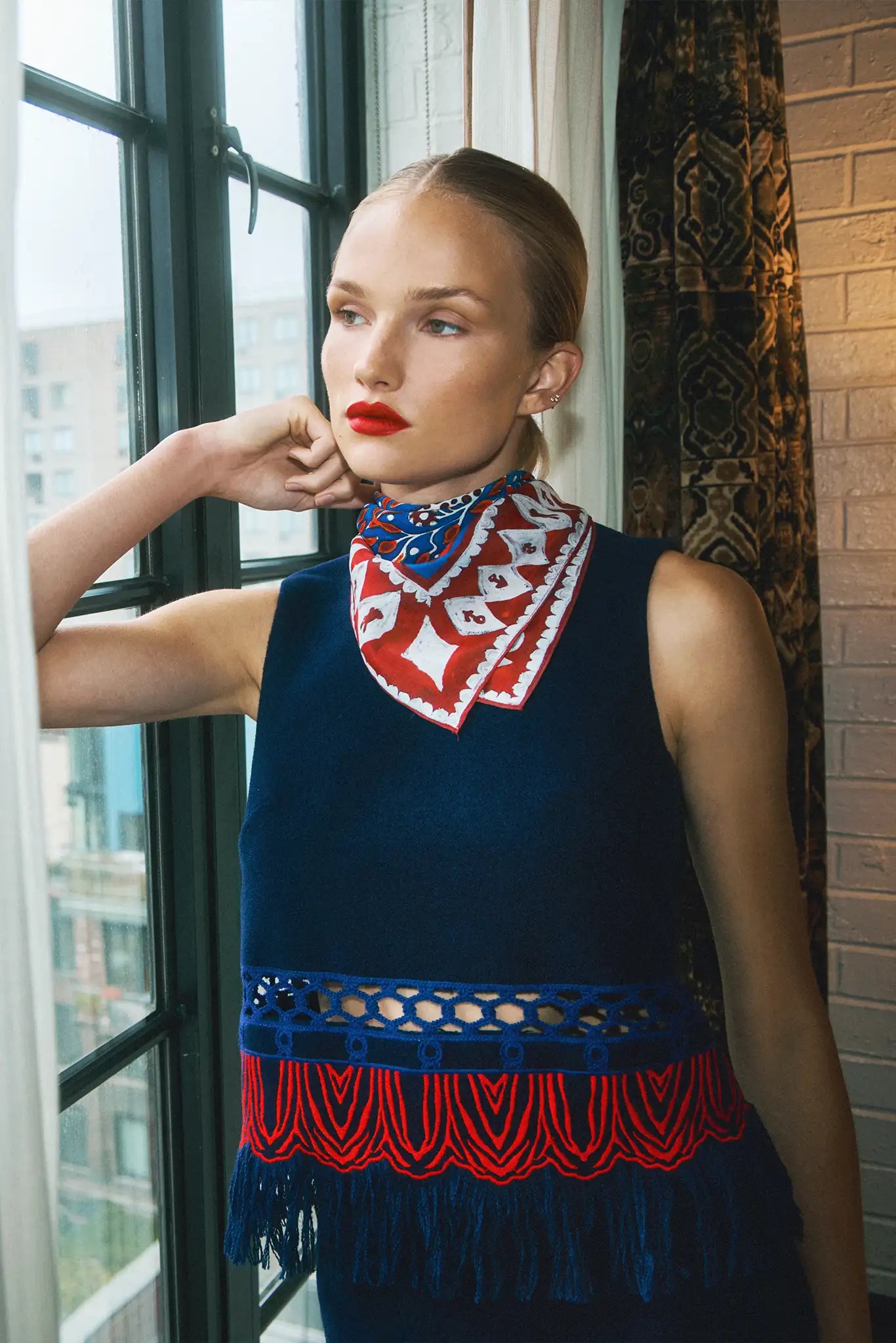 The Astor Top is designed with a crew neckline, button keyhole closure, and sleeveless silhouette.