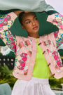 A cropped long-sleeve quilted jacket with a wooden toggle closure in multiple pastels.