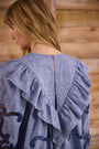 Blue cut-out embroidered linen, crew neckline, softly ruffled yoke, long sleeves with button cuffs