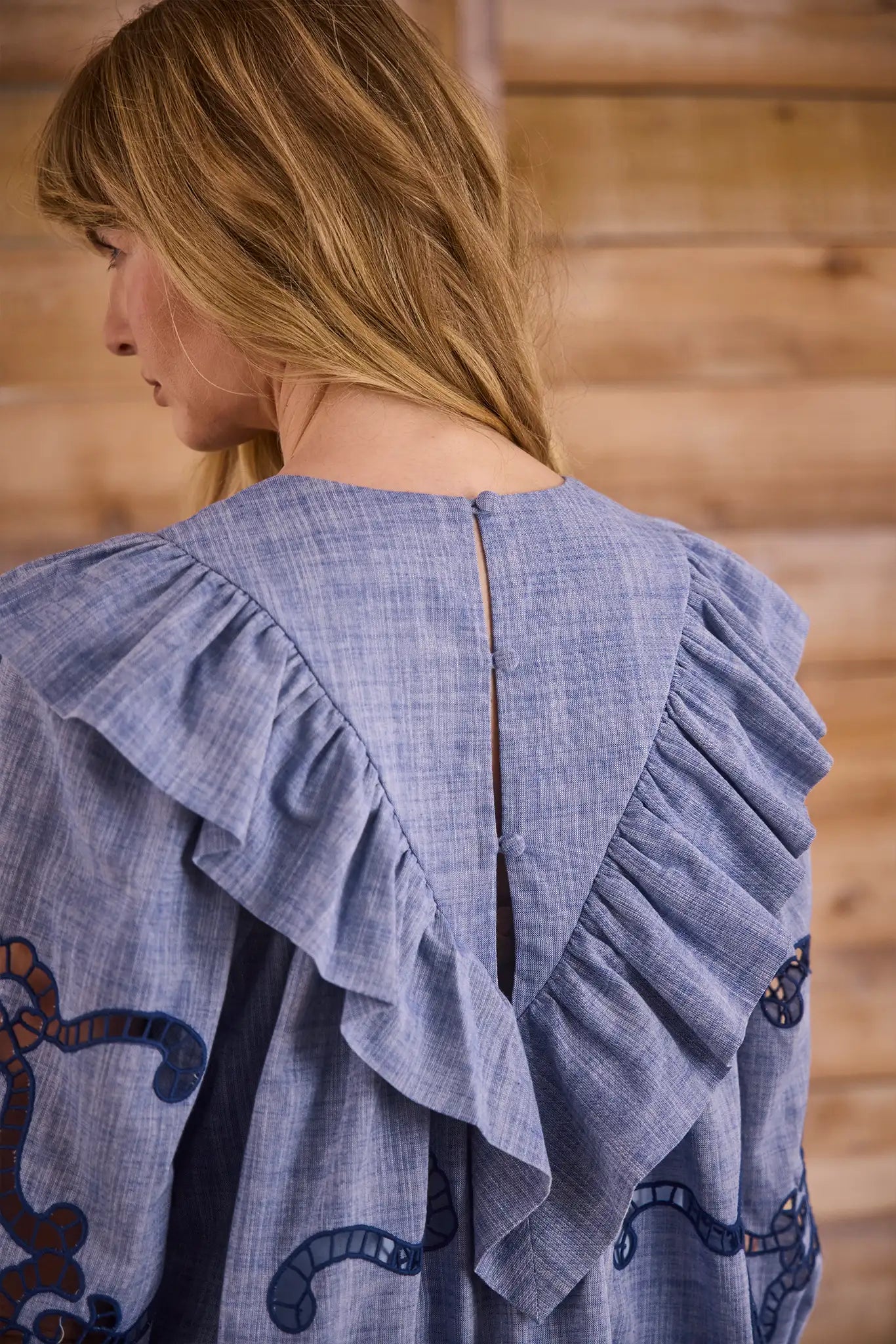 Blue cut-out embroidered linen, crew neckline, softly ruffled yoke, long sleeves with button cuffs