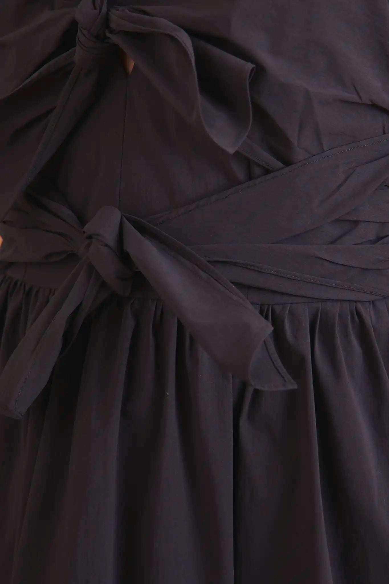 The Calista Dress has a V-neckline, cap sleeves, adjustable tie-front details and a full skirt.