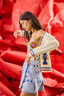 The Callen Cardigan in Lobster Multi paired with bathing suit in coastal conversation and bay skirt.