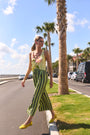 The Carsyn Tank in Quiet Bloom paired with Cyprus Pant in Evergreen Stripe in front of palm trees.