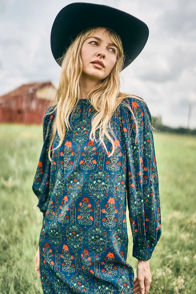 The Crosby Dress has a shirred round neckline, long sleeves, banded cuffs, and straight, silhouette.