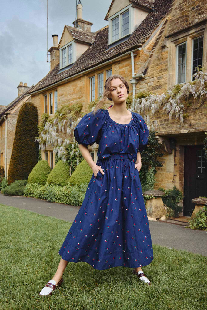 The Tatum midi skirt has a covered elastic waist, a relaxed fit, and an embroidered floral print.