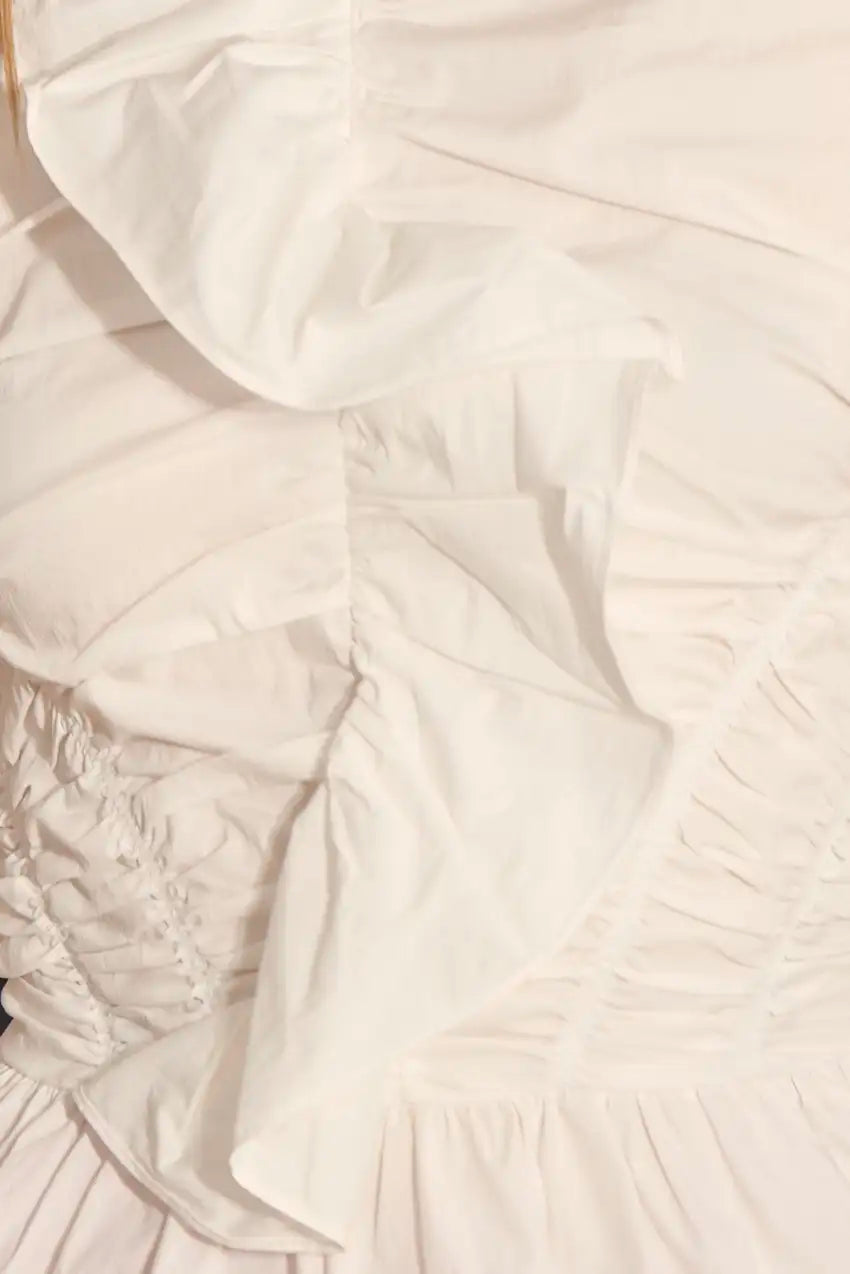 The Doering Top is a fitted V-neck silhouette with ruffles, shirring, and a peplum waist. 