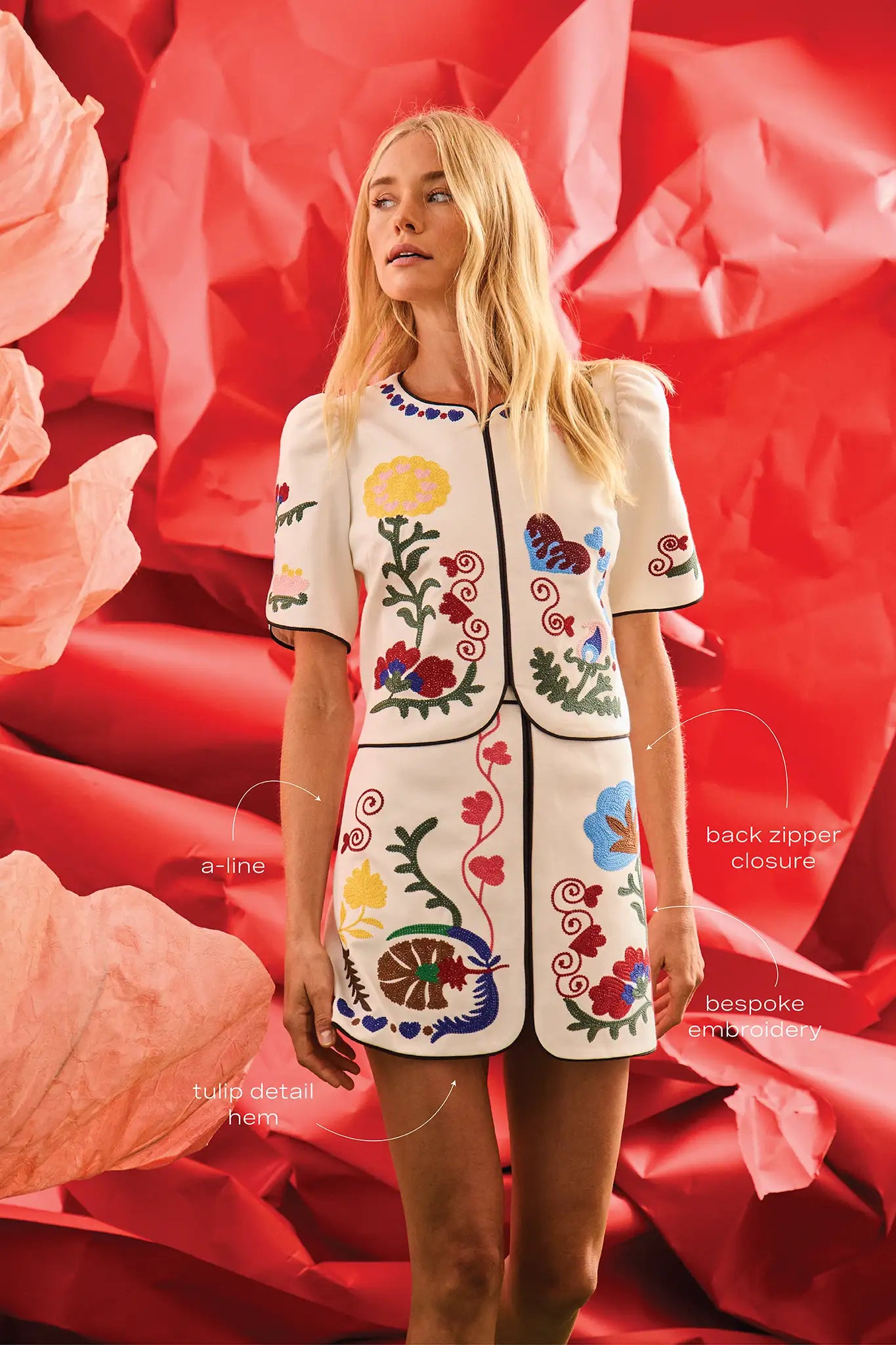 The Dottie Mini Skirt is a white A-line skirt with fitted waist and colorful hem throughout.