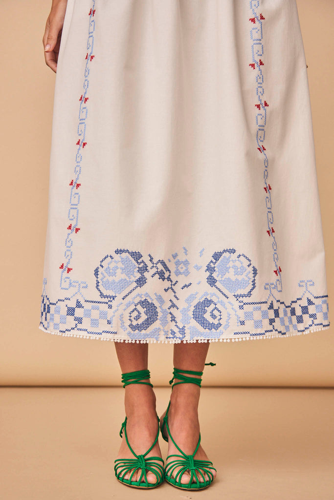 The Tanner skirt has intricate embroidery, pom-pom trim at the hem, and a fully lined skirt.