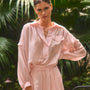 The Evangeline Shirt in Pink Sand paired with the matching Whisper Pant with palm leaves background.