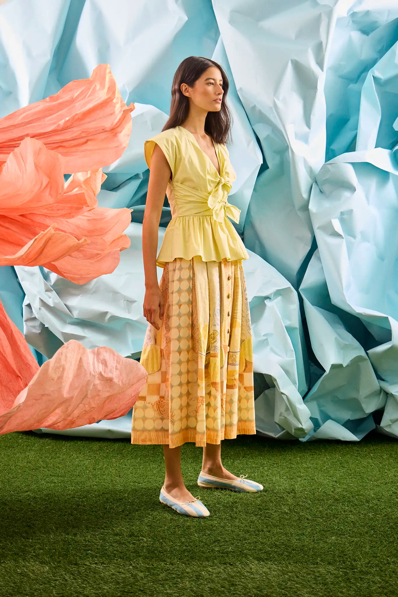 Eva Skirt in Still Life Symphony paired with Everly Top in Lemon Meringue, in front of colorful wall.