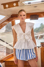 The Everly Top in white paired with blue and white Courtland short on model posed on boat