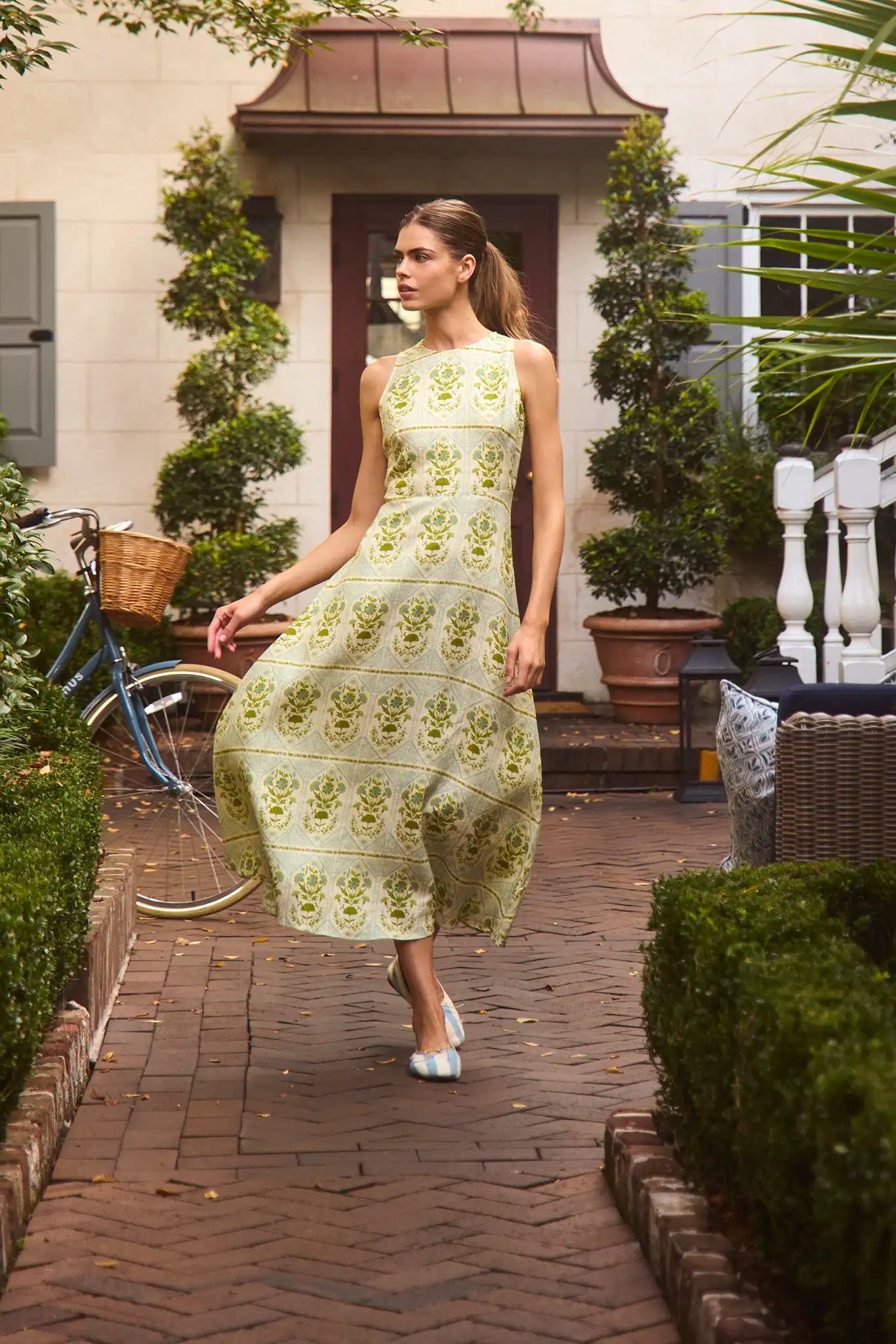 Faith Dress in Green Trellis modeled outside in front of greenery.