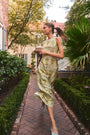 Faith Dress in Green Trellis modeled outside in front of greenery.