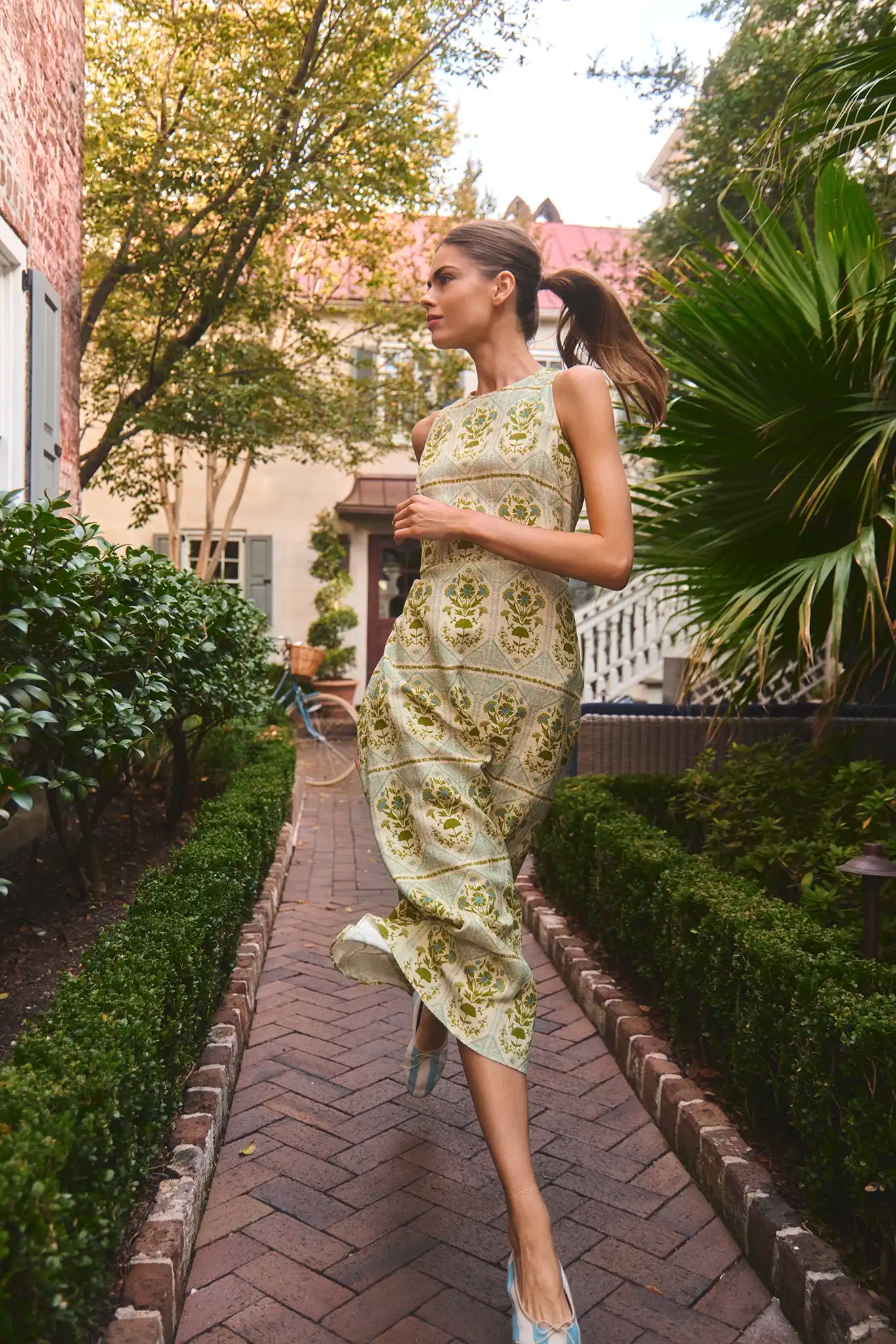 Faith Dress in Green Trellis modeled outside in front of greenery.