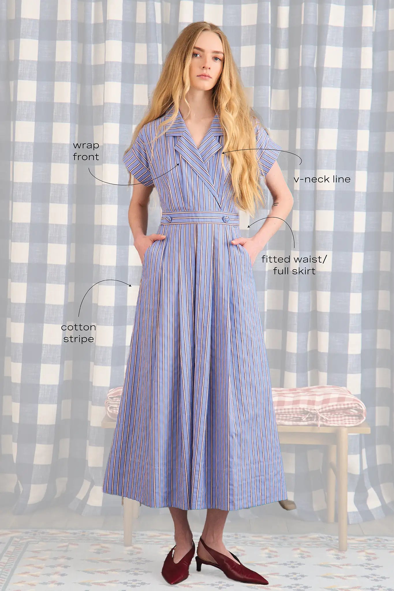 The Sloane Dress has a V-neckline, short banded sleeves, a fitted waist, and full midi-length skirt.