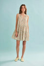 The Fawn Dress in Coral Multi paired with pale yellow shoes on a blue background.
