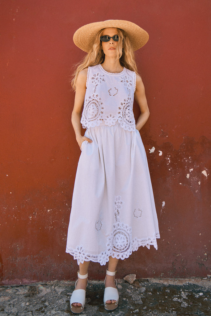 The Corrine midi skirt has intricate embroidery detailing and an eye-catching lace scalloped hem.