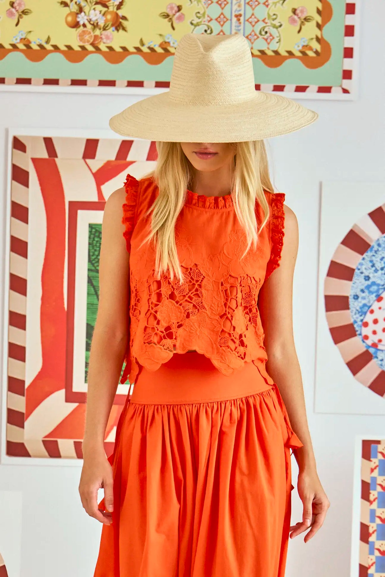 The Francesca Top is a sleeveless top with cutout embroidery and a cropped profile.
