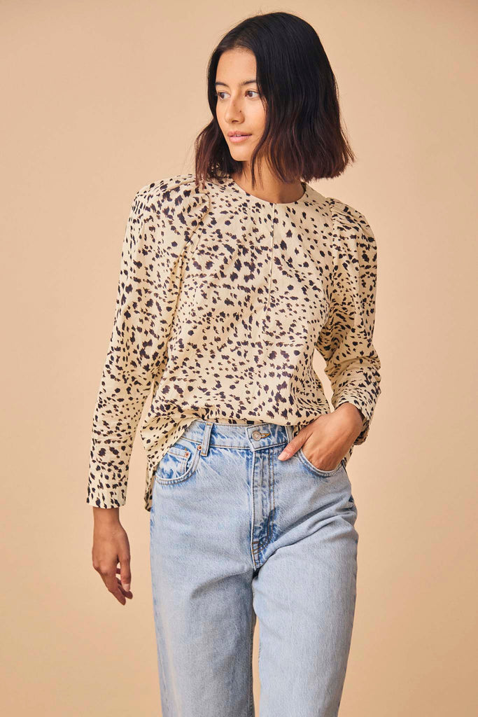 The Harris animal print top has a round neckline, long sleeves, puff shoulders and a shirttail hem.