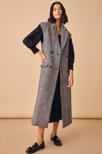 The Mirian tweed vest is double-breasted with shoulder pads, a lapel collar, and a vent at back.