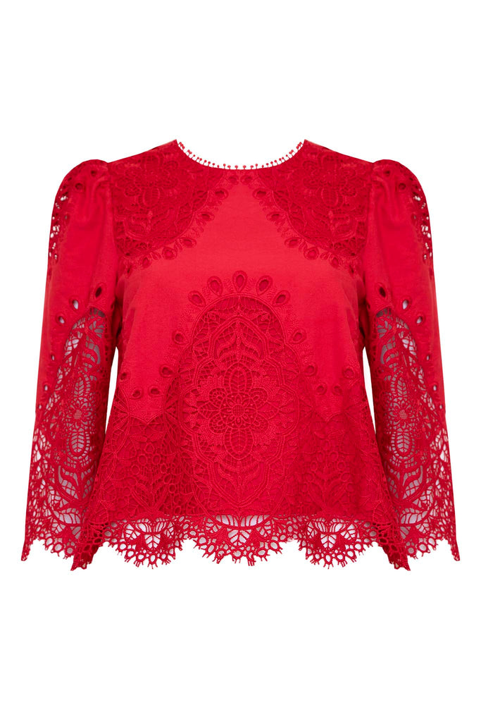 The Harriet Top has a round neck, a scalloped edge hem with bobble trim, and eyelet lace embroidery.