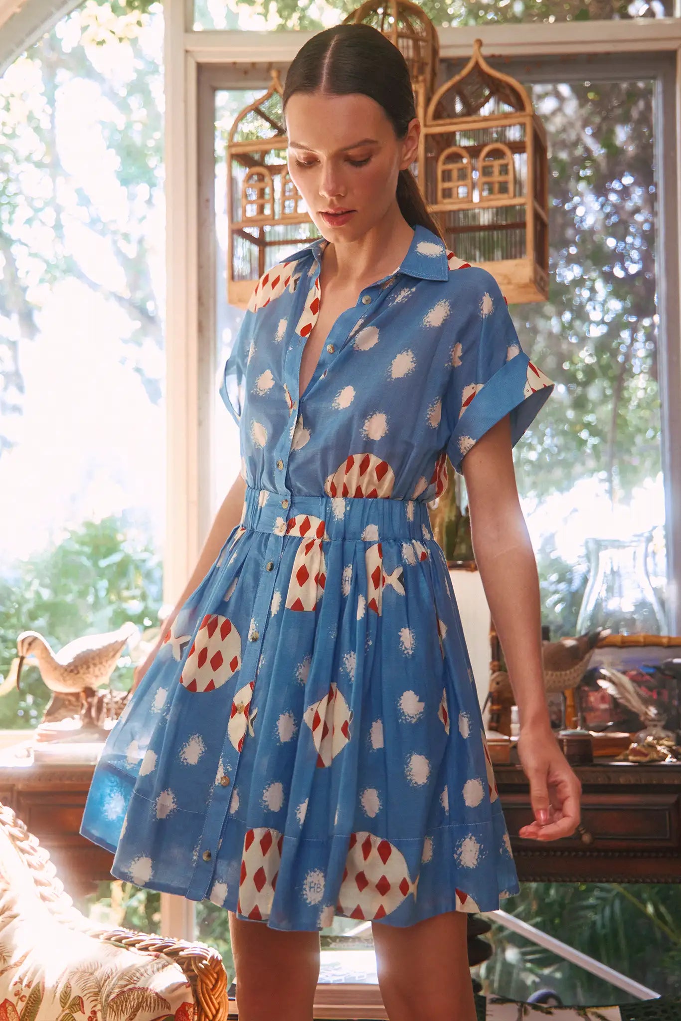 The Howard Dress has a collared bodice, banded short sleeves, button front, and an elastic waist.