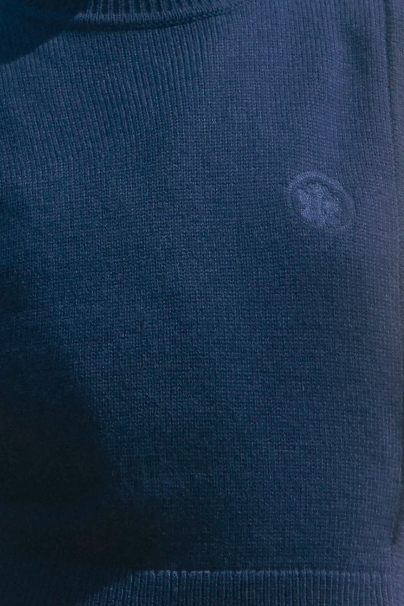 Navy wool blend turtleneck with an open side seam with embroidered eyelet ties.