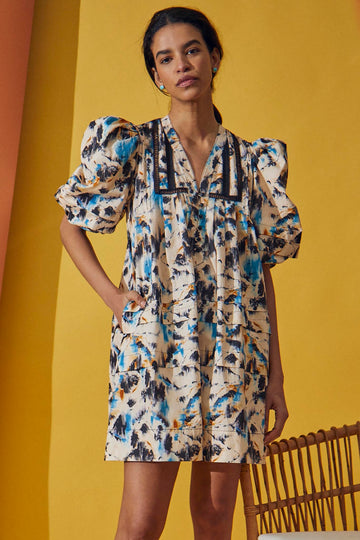 The Jenkins dress has inserted ladder trim, a v-neckline, partial button placket, and puff sleeves.