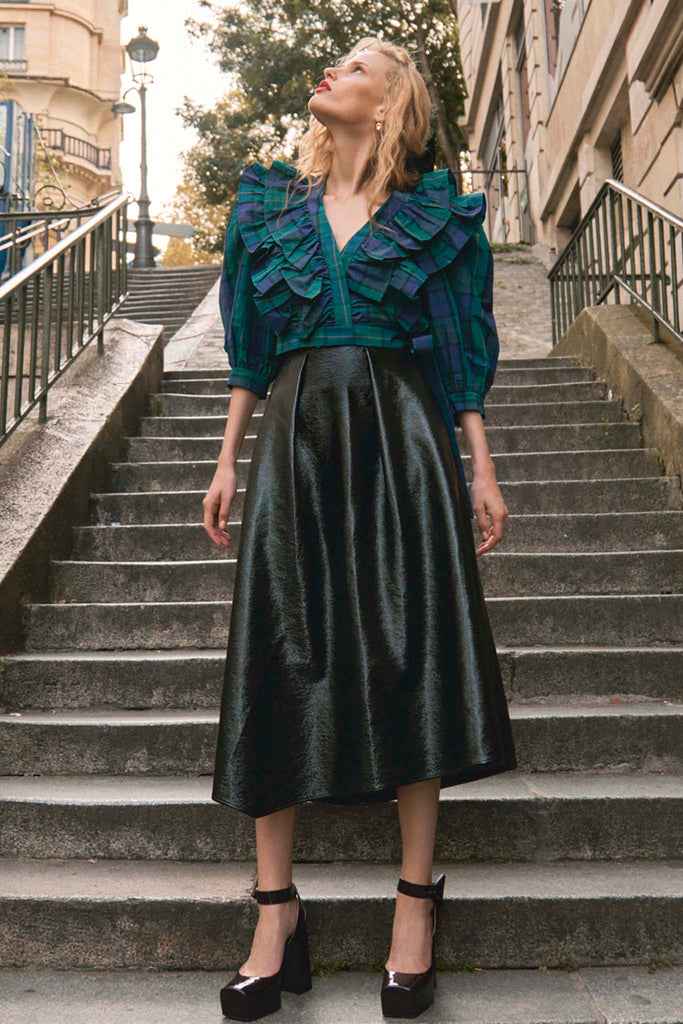 A pleated waist full skirt designed in faux patent leather for a high shine, ready to party look.